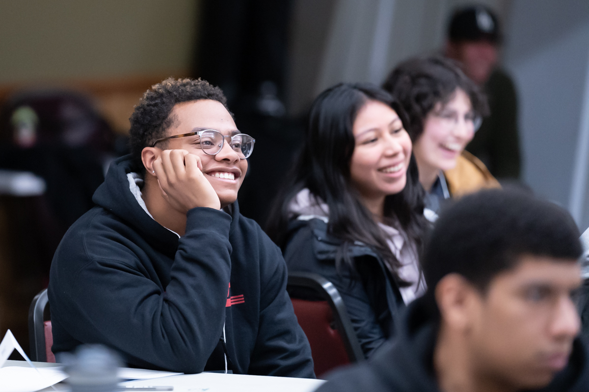 two students smiling and listening at sophomore summit